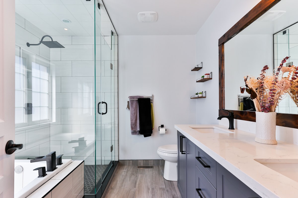 Renovated bathroom with large-format tile, a glass shower enclosure, and a floating vanity